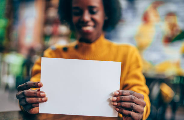Female hands holding white empty blank paper page with copy space.