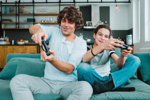 istock Father and son playing digital games at home 1202857795