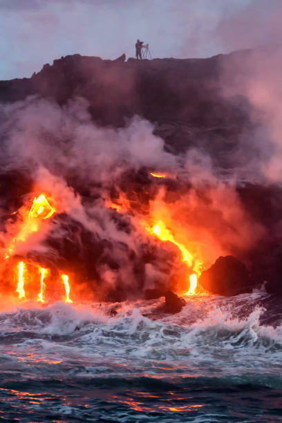 Molten lava flowing into the ocean Molten lava flowing into the Pacific Ocean on Big Island of Hawaii at sunrise pele stock pictures, royalty-free photos & images