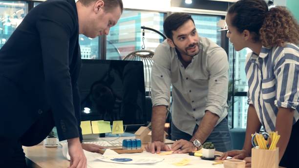 istock Creative business people group having conversation at office desk in workplace. 1202870141