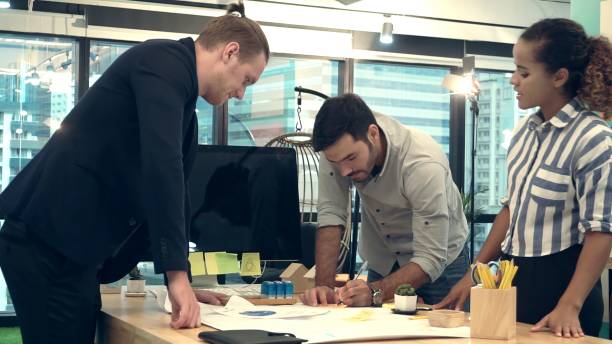istock Creative business people group having conversation at office desk in workplace. 1202870145