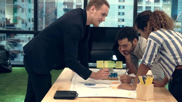 istock Creative business people group having conversation at office desk in workplace. 1202870158