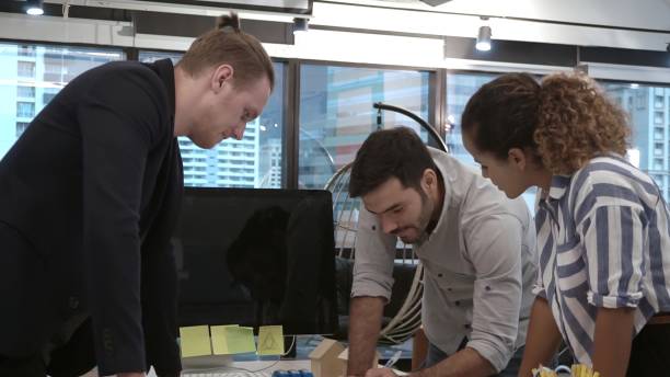 Creative business people group having conversation at office desk in workplace.