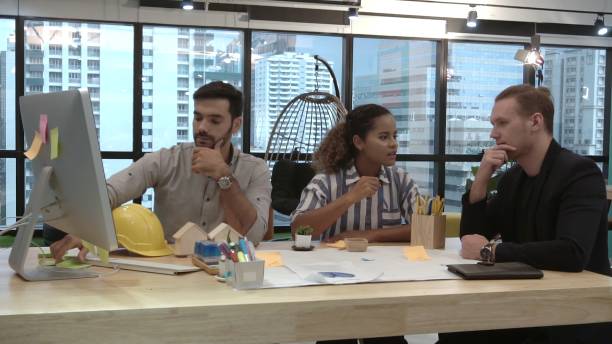 istock Creative business people group having conversation at office desk in workplace. 1202870202