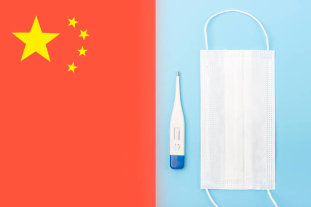 istock White mask and thermometer on blue background and chinese flag 1202870682