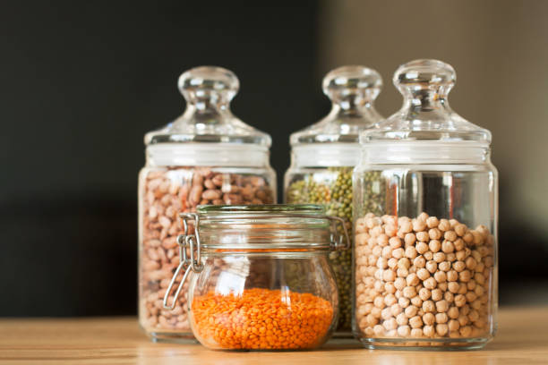 Glass jars with beans in the minimalistic interior. Peas, lentils, mung bean, beans and chickpeas as sources of vegetable protein. Zero waste concept, plastic-free, eco-friendly shopping, vegan