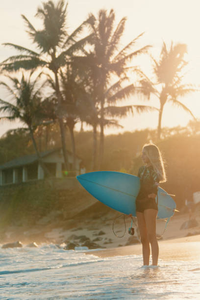 istock Adaptive surfer holding her surfboard and looking out towards the ocean 1202876389
