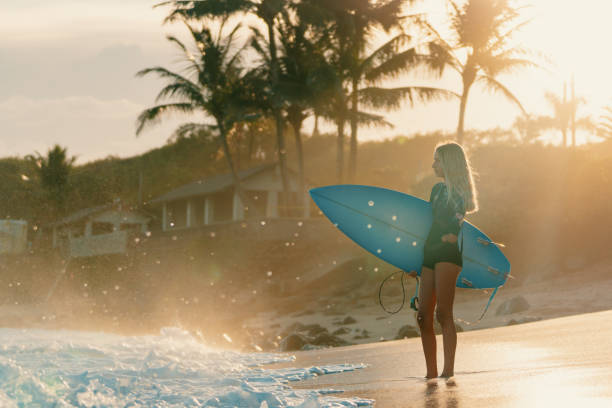istock Adaptive surfer holding her surfboard and looking out towards the ocean 1202876393
