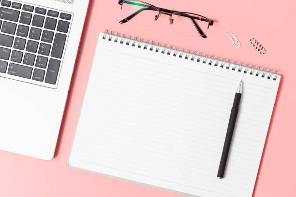 istock Modern workplace, laptop and notebook on a pink background top view, copy space 1202881600