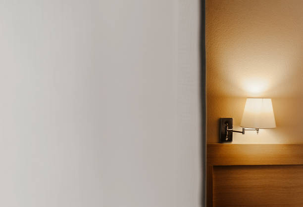 istock element of a cozy warm interior, elegant beige sconce lamp on the wall with white curtains nearby, it is possible to insert an inscription 1202882830