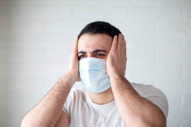 istock Young man standing with mask on his face 1202884619