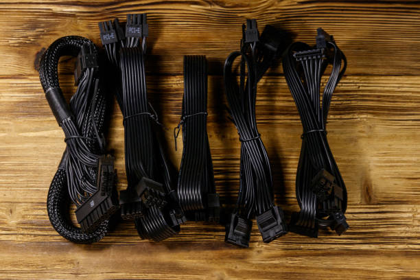 istock Set of cables for computer PSU on a wooden desk 1202884776