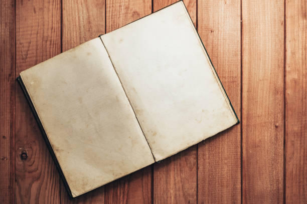 istock Open Vintage book on a red wooden table background. Top view. 1202888939