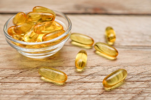 Omega 3 capsules for dieting concept on wooden background
