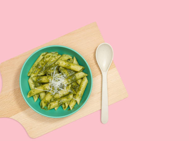 istock Penne pasta in pesto sauce and cheese decorated on a board, 1202889359