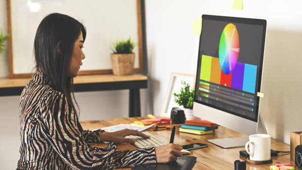istock Creative designer sitting at wooden working desk using digital tablet for selecting color from color management/color palette program. Graphic design concept 1202890059