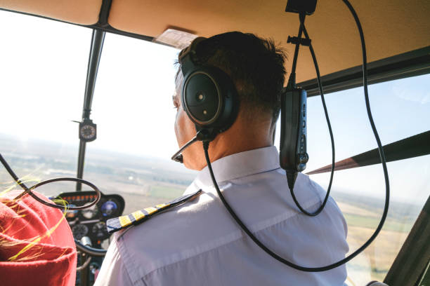 istock Pilot flying a helicopter with passenger in cockpit 1202894169