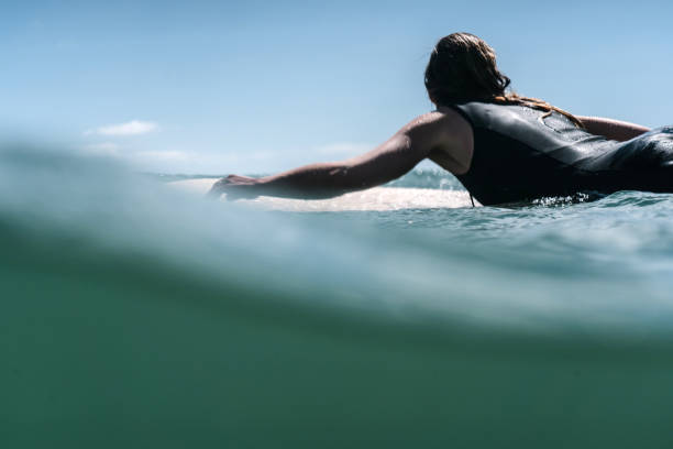 istock Surfer girl puddle in the ocean 1202896335