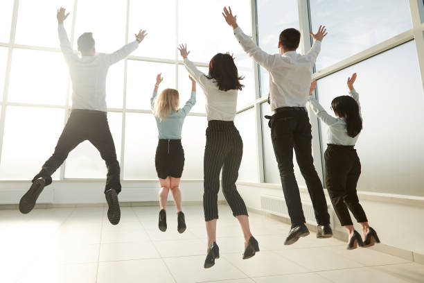 istock rear view.happy business team, having fun in a bright new office. 1202896351