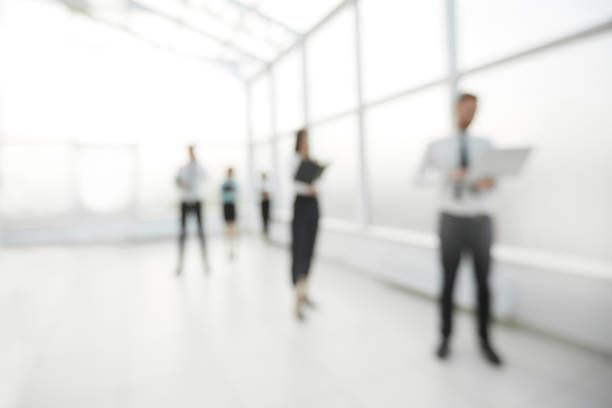 istock blurred image of employees standing in the office lobby 1202896387
