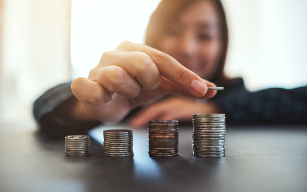 istock Businesswoman holding and stacking coins 1202896849