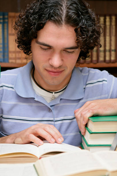 istock Student reading books at the library 1202896960