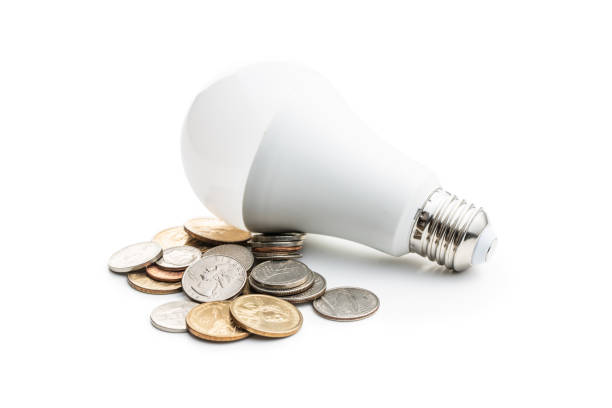 энергосберегающие лампочки и долларовые монеты. светодиодная лампочка. - daylight savings стоковые фото и изображения