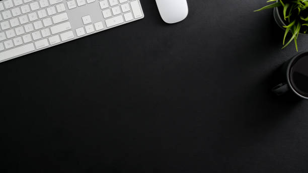 istock Overhead shot of dark modern workspace with computer keyboard, coffee cup and copy space 1202900076