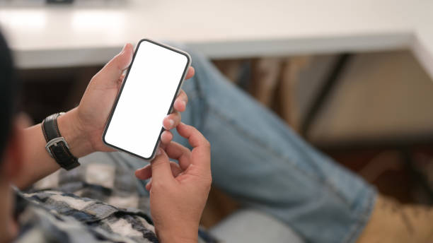 istock Young man holding blank screen smartphone  with relax sitting position 1202900228