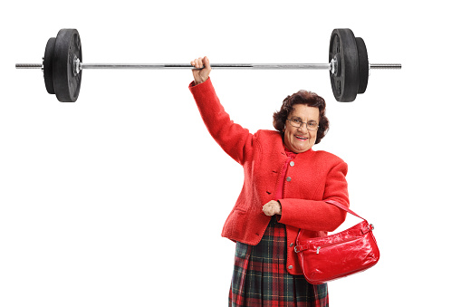 Elderly lady lifting a barbell with one hand isolated on white background