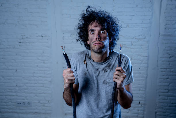 istock Funny man with burns and smoke holding electrical cable after getting a electric shock at home. Sad husband with dirty burnt face guilty expression. Domestic accidents, DYI and Electricity danger. 1202905702