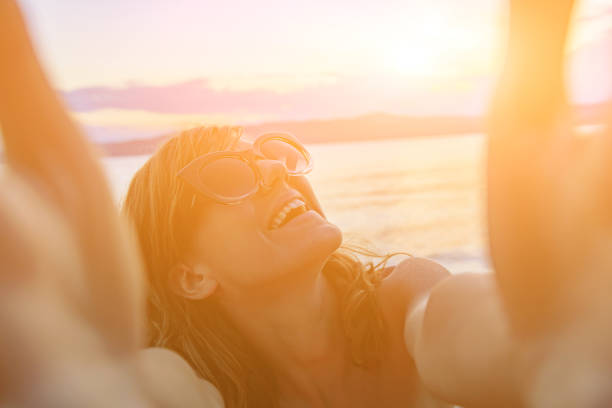 Smiling girl making selfie on a sunny beach.