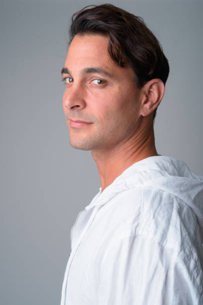 istock Closeup profile view of handsome Hispanic man looking at camera 1202907105