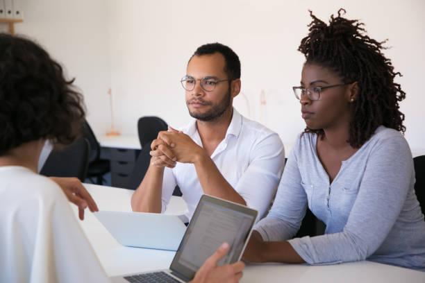 istock Focused colleagues listening information while sitting at table 1202907275