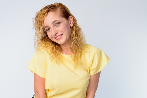 Studio shot of beautiful multi ethnic woman with curly blond hair against white background