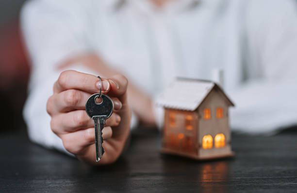 istock small house with luminous windows in female hands 1202910153