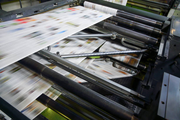 Newspaper printing press in a printing plant Printing press machine printing broadsheet newspapers in a printing plant. printout stock pictures, royalty-free photos & images