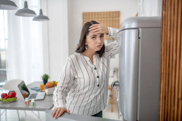 istock Dark-haired woman in a striped blouse feeling frustrated 1202911235