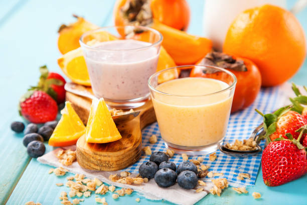 istock Orange persimmon blueberry smoothie with granola  and fruits. Selective focus. Copy space 1202911330