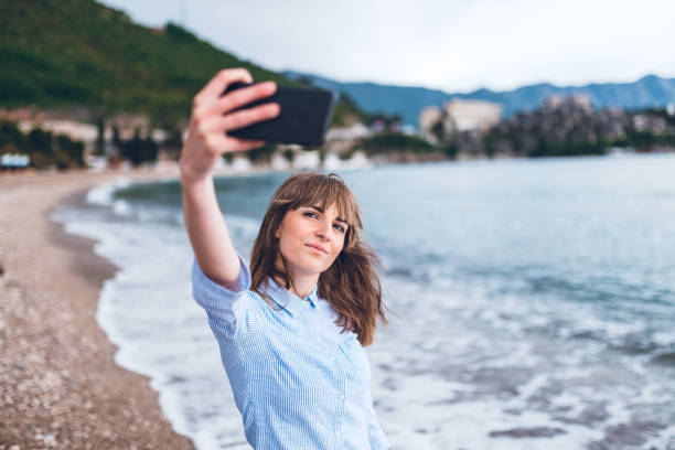 istock Young woman taking selfie at the beach 1202911642