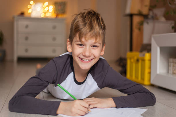 istock Happy boy coloring on papers at home. 1202912751