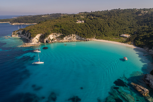 Amazing color of water and landscape on island of Antipaxos, Greece. Sailboat moored in shallow water near beach