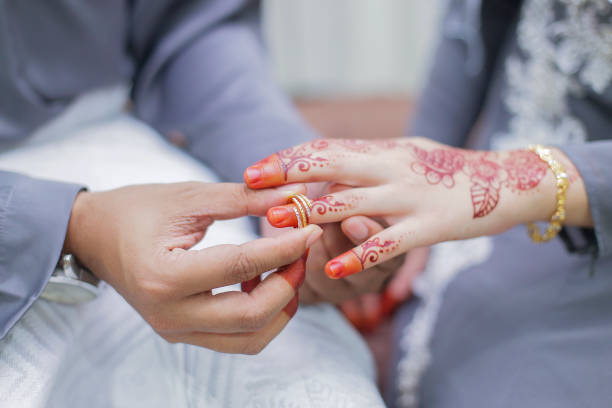 istock Groom put a wedding ring on bride hand 1202916460