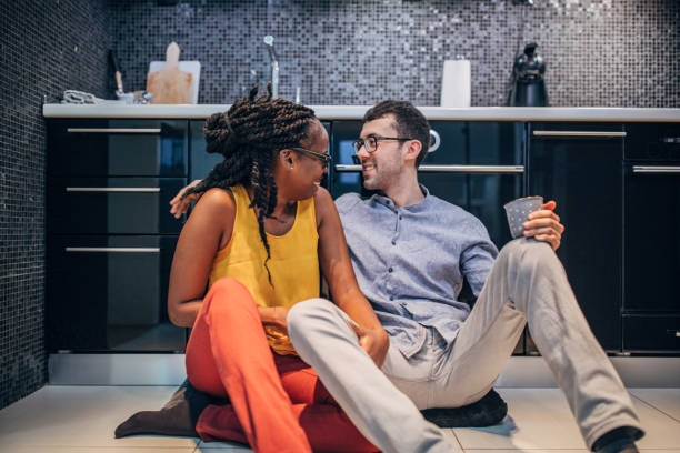 istock Young couple sitting on the kitchen floor 1202917263