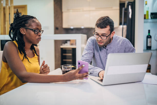 istock Beautiful young couple sitting on the kitchen counter 1202917491