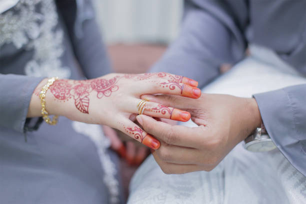 istock Groom put a wedding ring on bride hand 1202917528