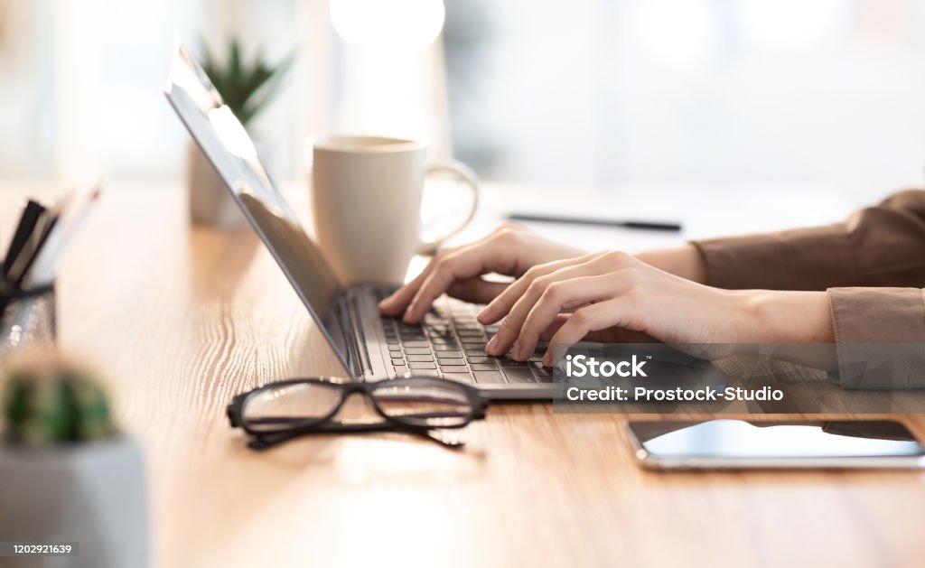 Woman using her personal computer at cafe Doing Homework. Close up of teenager typing on laptop, browsing information, preparing project at home, empty space Laptop Stock Photo