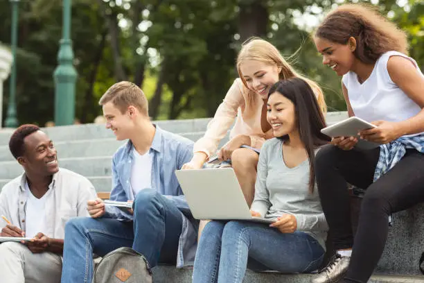 Photo of Group of positive students doing project together