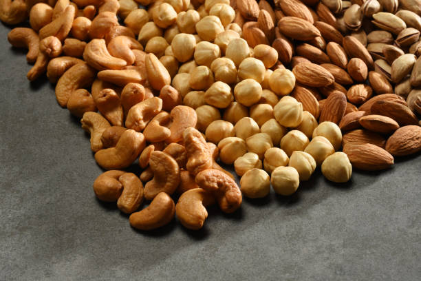 istock Group of nuts, hazelnuts, almonds, pistachios, cashews on the gray stone texture 1202924046