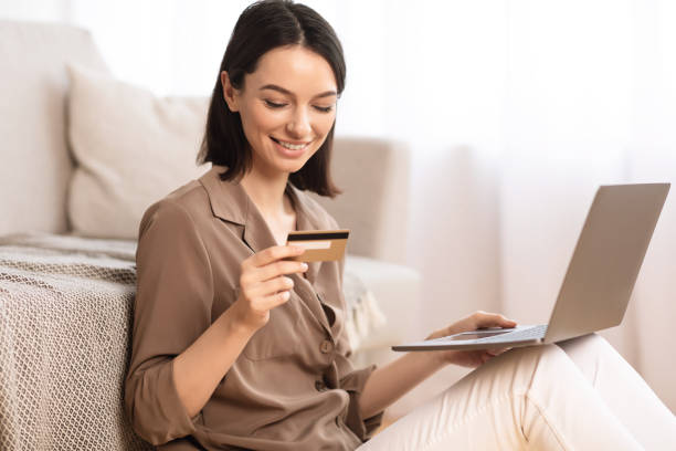 istock Young woman making purchases sitting on the floor 1202924086